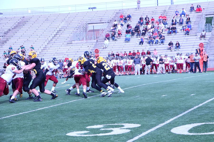 The football team tries to sneak the ball past the 35 yard line.