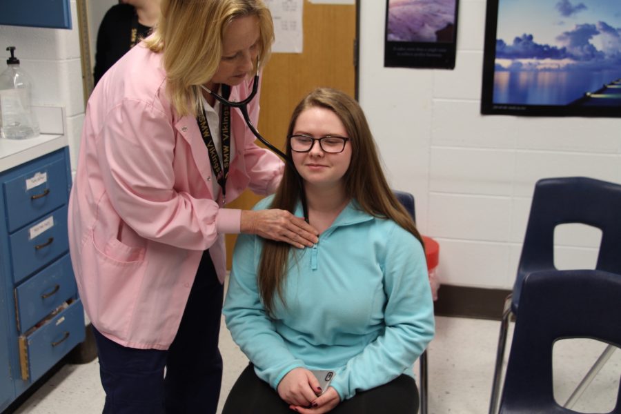 Nurse Marilyn Mortimer takes vitals on a student patient.