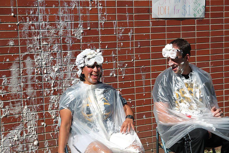 Math teachers Sarah Gonzales and Ryan Darst get involved in the annual Writers’ Walk event by participating in the pie booth. Students can pay $1 to throw a pie at their teacher’s face, and the proceeds support the publication of the student-produced literary magazine, Out of Hand, which is published each year with both original writings and artwork. 
