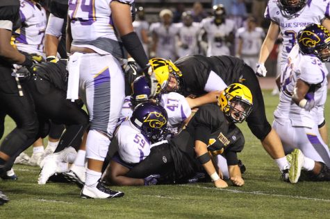 Zach Witters struggles under pile of Blue Springs players (Mikaela Kelly-Price)