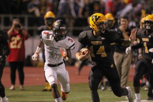 Senior Zach Witters stiff arms a defender as he runs down the field