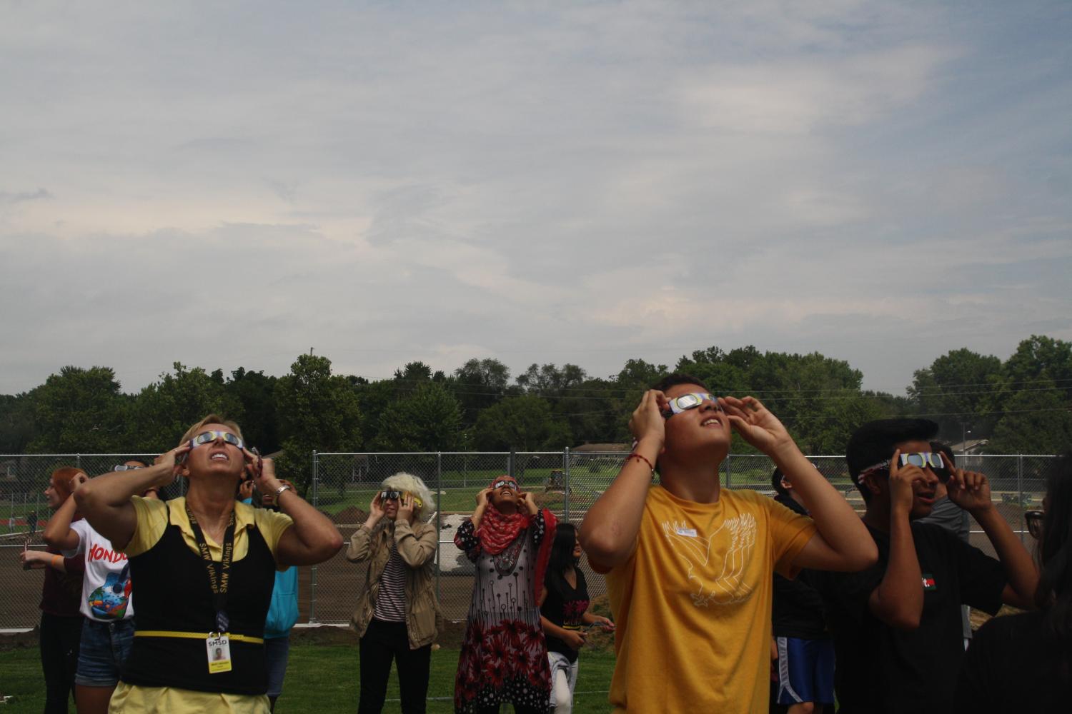 Students+and+faculty+look+towards+the+eclipse+with+their+special+glasses.