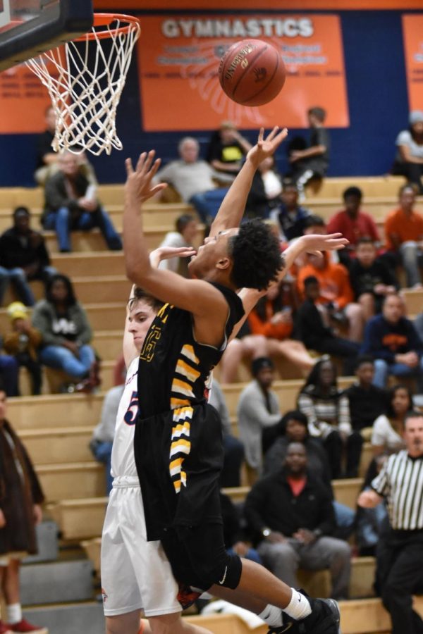 Junior Eric Rhymes completes a layup vs Olathe East, Varsity, December 1