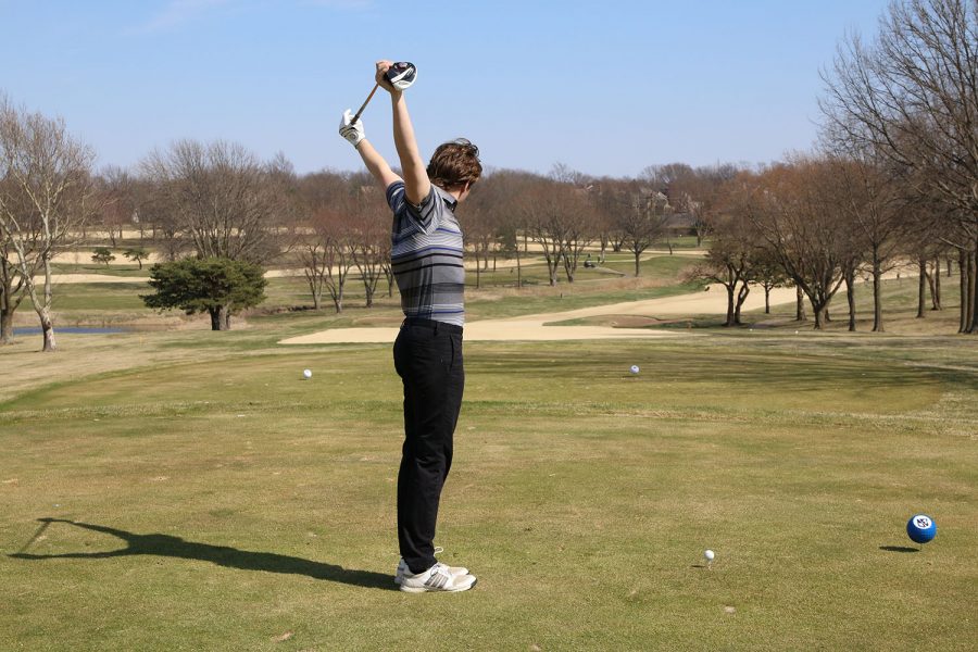 4 year team member, Sam Weiss, stretches at the beginning of the round to prepare to hit his tee shot. 