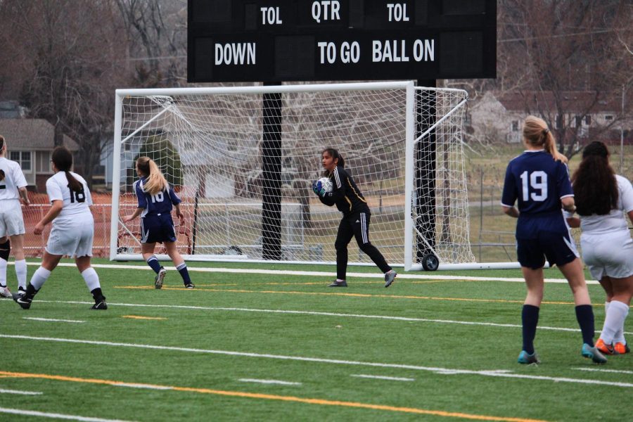 Goalie Lili Varela scoops up the ball just before it goes in. 