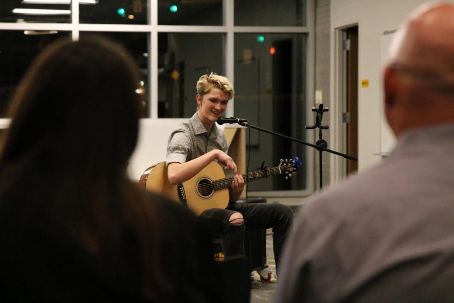 Aiden Sherrill singing while playing the guitar