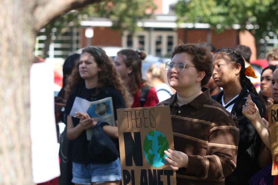 Students hold up signs to show their participation in the walkout.