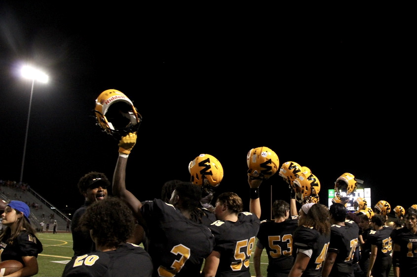 SMW teammates line up and raise their helmets in support for their players. 